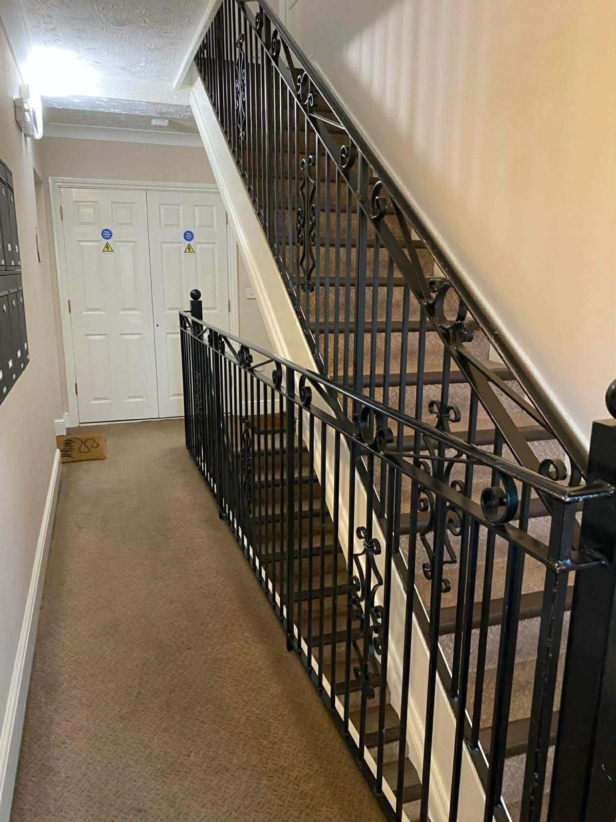 Wrought iron balustrade and carpeted stair in the second Epsom block beside the post boxes