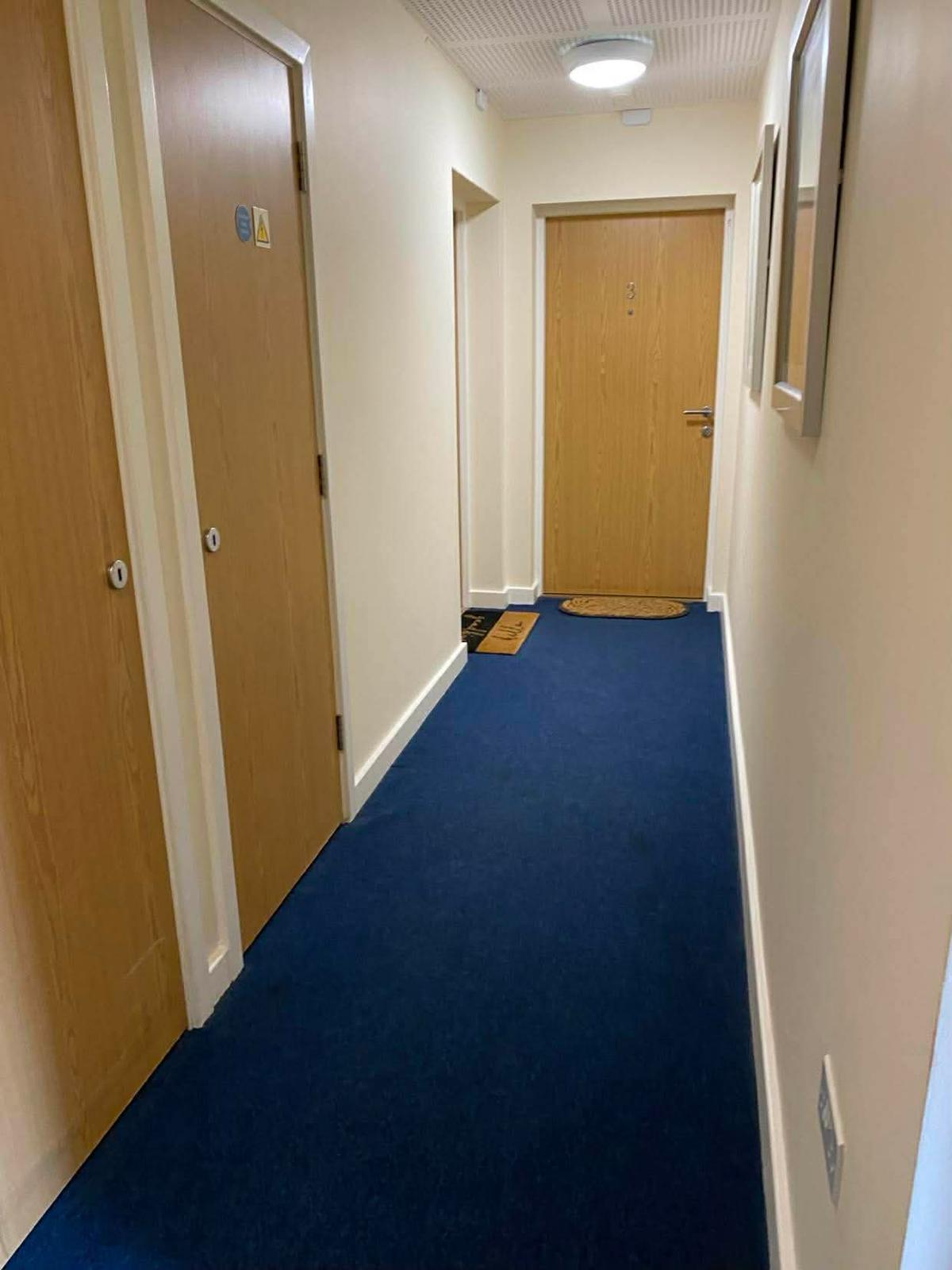 Blue carpeted communal corridor in the Kingston block with oak flat doors