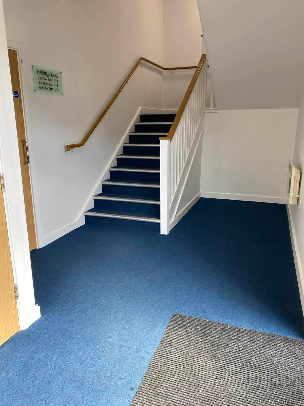 Entrance lobby of the Kingston block with the building sign, stair and barrier matting