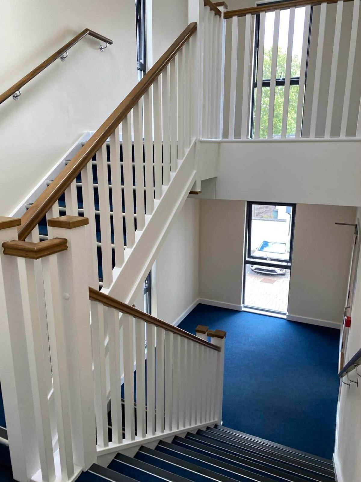 Open stairwell in the Kingston block with a white balustrade and blue carpet