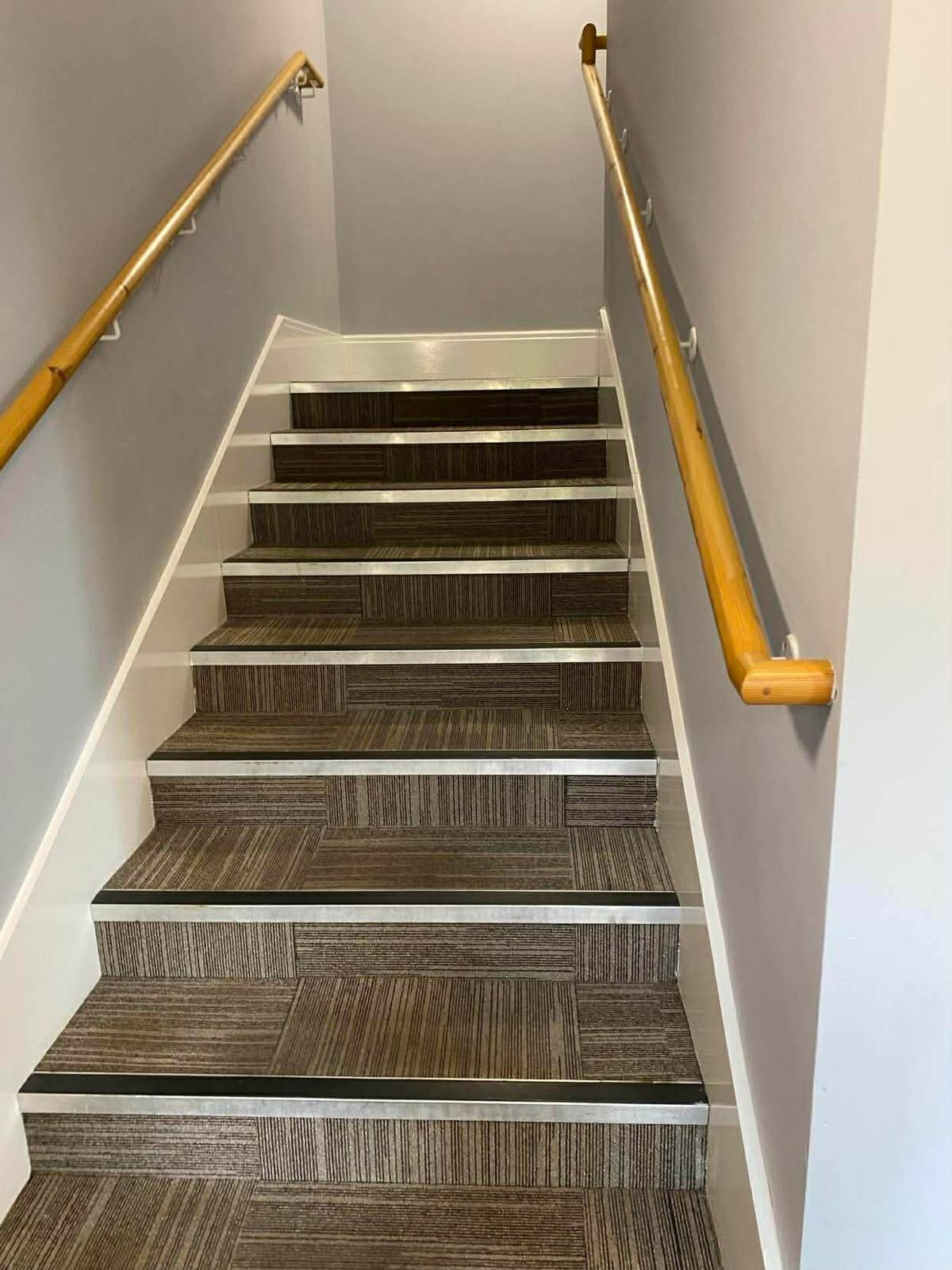 Carpet-tiled staircase with aluminium stair nosings in the Kingston block