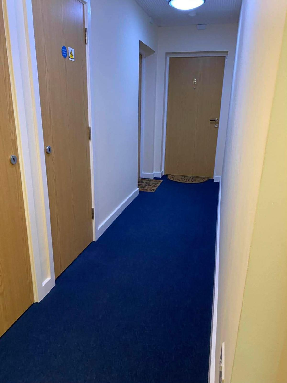 Kingston corridor with a numbered oak flat door and residents' doormats