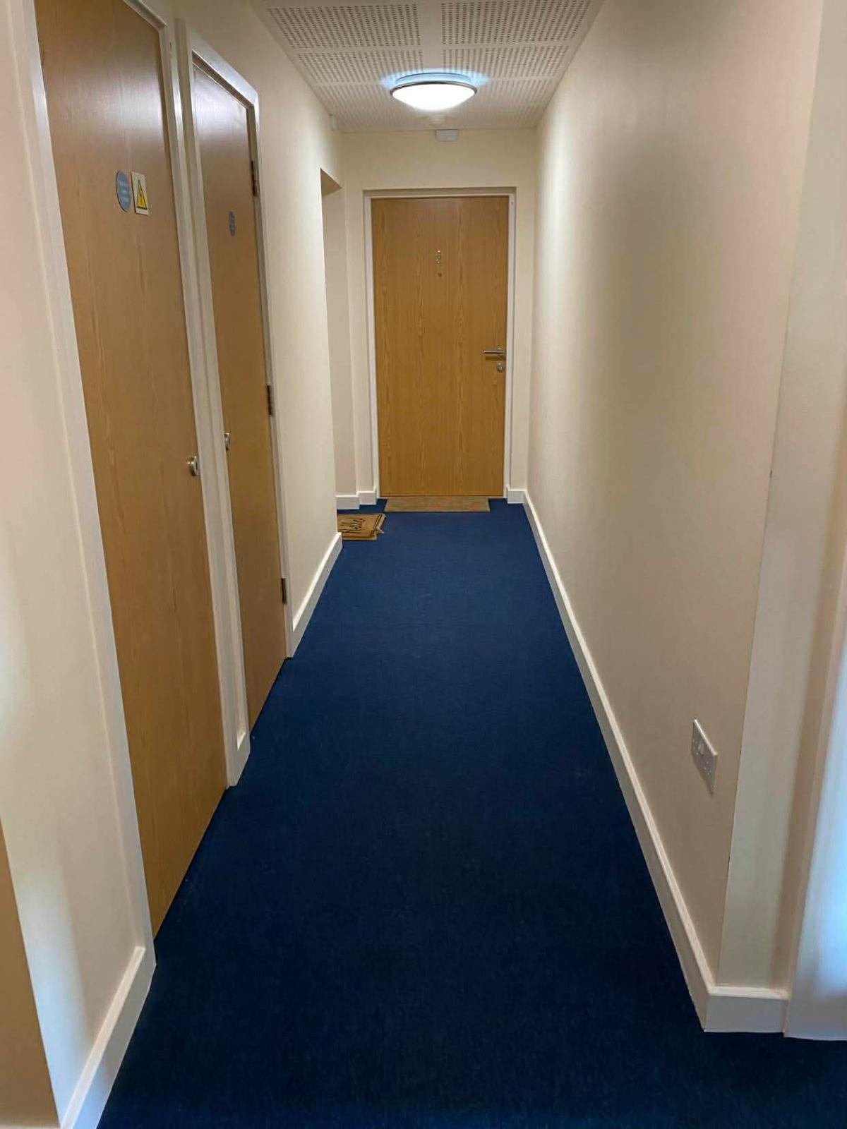 Kingston communal corridor with riser cupboard doors and a flat entrance door