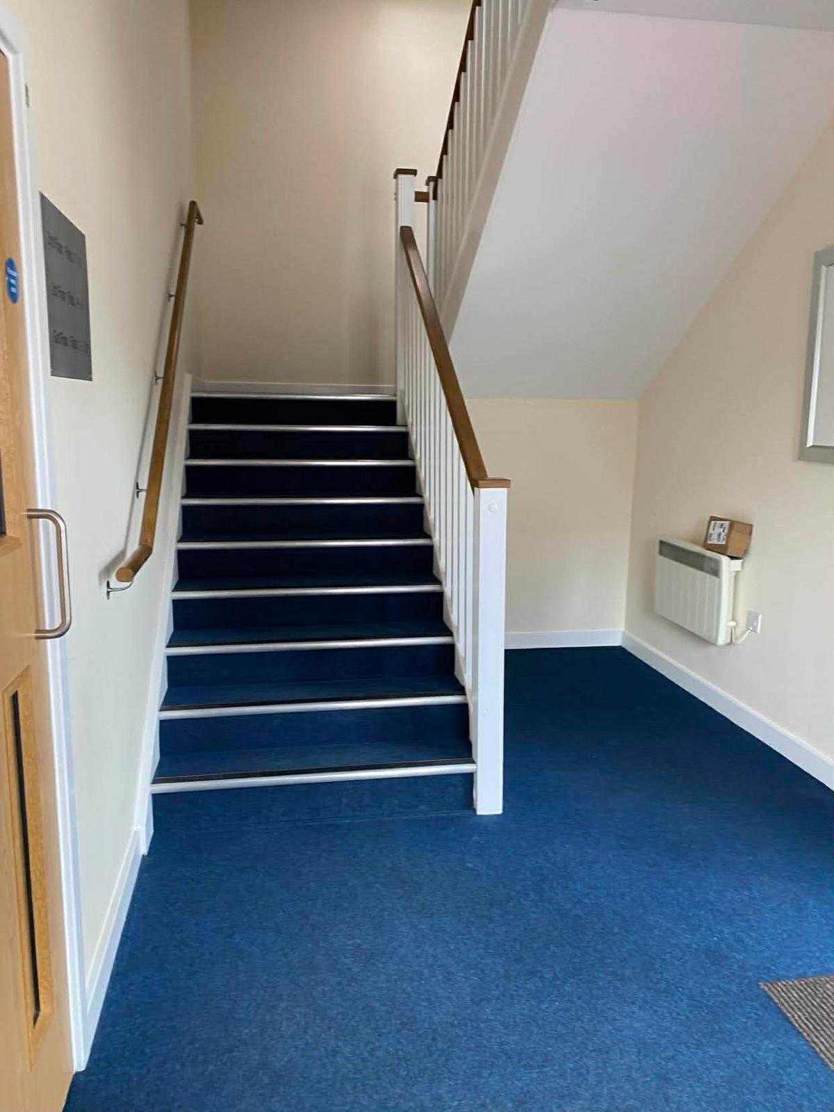 Ground floor stair and hallway in the Kingston block with a wall heater and notice board